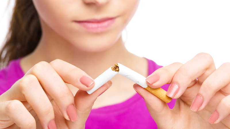 Kvinna som bryter en cigarett.