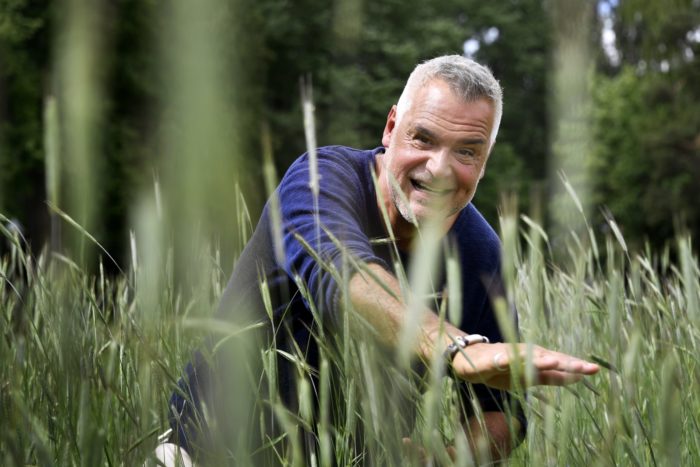 Ernst Kirchsteiger kikar fram bakom gräs i juni 2018.